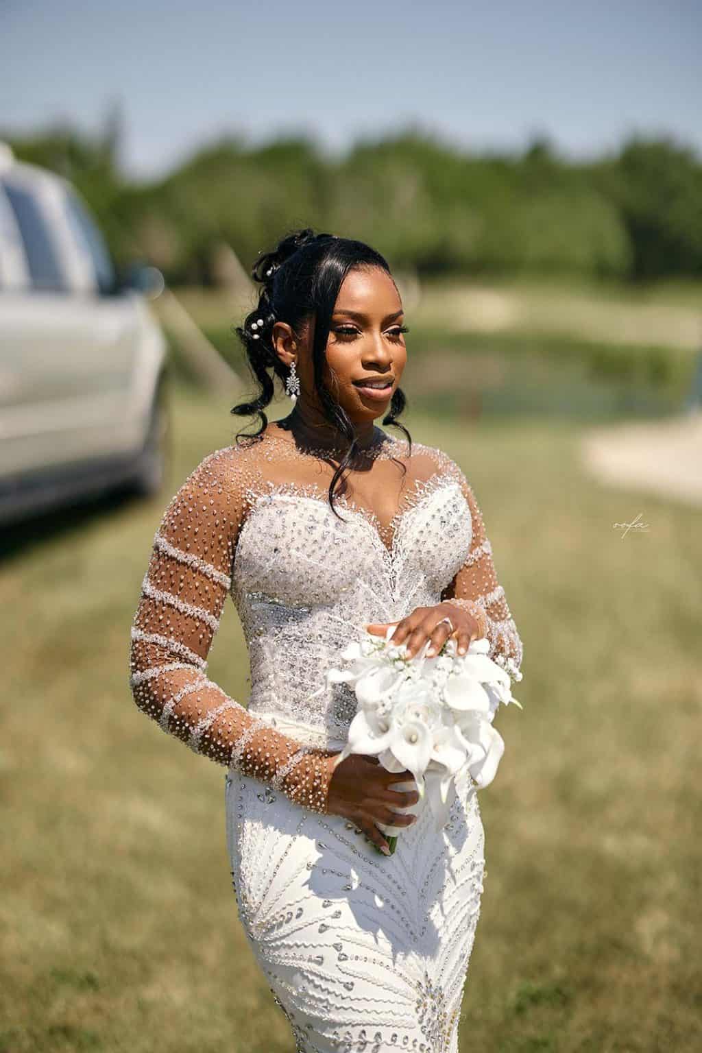 Beautiful bride holding a bouquet outdoors on a sunny day.